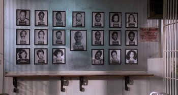 Movie still from “House Party 3” (1994), directed by Eric Meza – A group of black and white photos of people on a wall; Wide shot, High angle