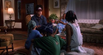 Movie still from “House Party 3” (1994), directed by Eric Meza – A group of people sitting around a living room table; Medium shot, High angle