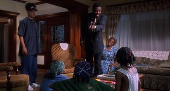 Movie still from “House Party 3” (1994), directed by Eric Meza – A group of people sitting in a living room; Medium shot, Over the shoulder angle