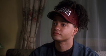 Movie still from “House Party 3” (1994), directed by Eric Meza – A young man wearing a baseball cap and a jacket; Close Up shot, Over the shoulder angle