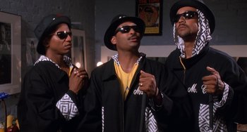 Movie still from “House Party 3” (1994), directed by Eric Meza – A group of men standing next to each other in a room; Medium shot, Low angle