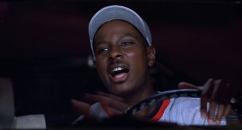 Movie still from “House Party 3” (1994), directed by Eric Meza – A person holding a tennis racquet on a tennis court; Close Up shot, Low angle