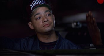 Movie still from “House Party 3” (1994), directed by Eric Meza – A man wearing a hat sitting in front of a window; Close Up shot, Low angle