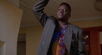 Movie still from “House Party 3” (1994), directed by Eric Meza – A man in a suit and tie raising his hand; Medium shot, Low angle