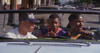 Movie still from “House Party 3” (1994), directed by Eric Meza – A group of young men riding in a car; Medium shot, Over the shoulder angle
