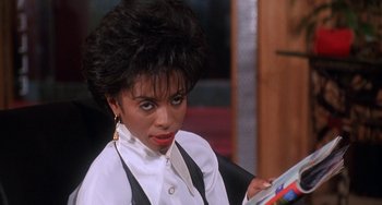 Movie still from “House Party 3” (1994), directed by Eric Meza – A woman in a white shirt is holding a book; Close Up shot, Over the shoulder angle