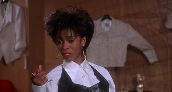 Movie still from “House Party 3” (1994), directed by Eric Meza – A woman in a white shirt and a black apron; Close Up shot, Over the shoulder angle