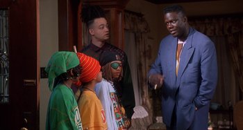Movie still from “House Party 3” (1994), directed by Eric Meza – A group of people standing next to each other in a room; Medium shot, Over the shoulder angle