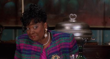 Movie still from “House Party 3” (1994), directed by Eric Meza – A woman sitting at a table with a glass of wine; Close Up shot, High angle