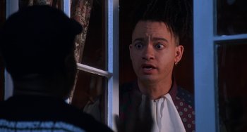 Movie still from “House Party 3” (1994), directed by Eric Meza – A man with dreadlocks is looking out of a window; Close Up shot, Over the shoulder angle
