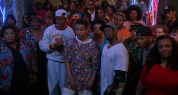 Movie still from “House Party 3” (1994), directed by Eric Meza – A group of people standing in front of a crowd of people; Medium shot, High angle