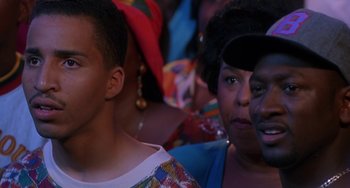 Movie still from “House Party 3” (1994), directed by Eric Meza – A group of people sitting next to each other on a stage; Close Up shot, Over the shoulder angle