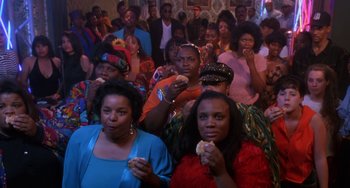Movie still from “House Party 3” (1994), directed by Eric Meza – A group of people sitting in a room eating food; Medium shot, High angle