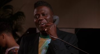 Movie still from “House Party 3” (1994), directed by Eric Meza – A man talking on a phone while wearing a suit; Close Up shot, Low angle