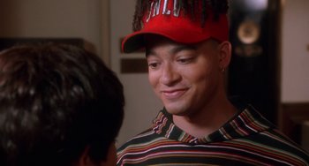 Movie still from “House Party 3” (1994), directed by Eric Meza – A man wearing a red hat and a striped shirt; Close Up shot, High angle