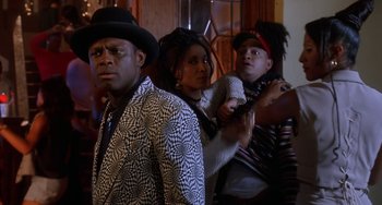 Movie still from “House Party 3” (1994), directed by Eric Meza – A group of people standing next to each other in a room; Medium shot, Over the shoulder angle
