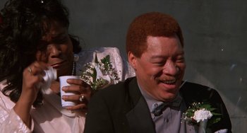 Movie still from “House Party 3” (1994), directed by Eric Meza – A man in a suit and tie holding a cup; Close Up shot, Low angle