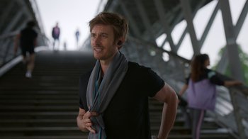 Movie still from “Emily in Paris” (2020), created by Darren Star – A man with a scarf around his neck; Close Up shot, Over the shoulder angle
