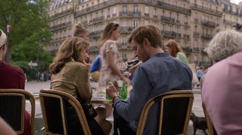 Movie still from “Emily in Paris” (2020), created by Darren Star – A man and a woman sitting at a table; Medium shot, Over the shoulder angle