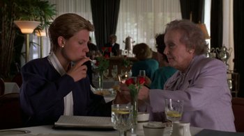 Movie still from “House of Games” (1987), directed by David Mamet – Two women are sitting at a table in a restaurant; Medium shot, High angle