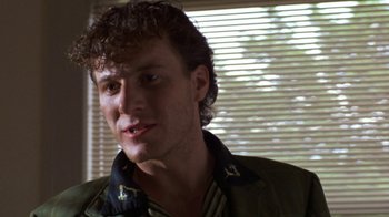 Movie still from “House of Games” (1987), directed by David Mamet – A person wearing a jacket near a window; Close Up shot, Low angle