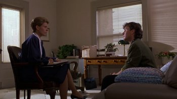Movie still from “House of Games” (1987), directed by David Mamet – Two people sitting in a room talking to each other; Medium shot, Over the shoulder angle