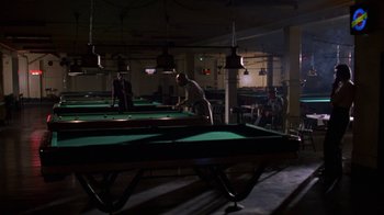 Movie still from “House of Games” (1987), directed by David Mamet – A group of people playing a game of billiards; Wide shot, High angle