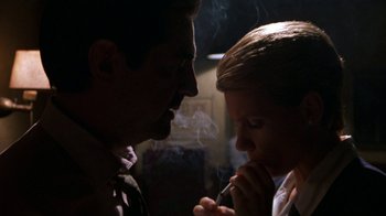 Movie still from “House of Games” (1987), directed by David Mamet – A man and a woman smoking a cigarette; Close Up shot, Low angle