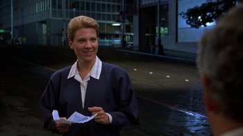 Movie still from “House of Games” (1987), directed by David Mamet – A woman standing in the street holding papers; Medium shot, Low angle