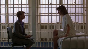 Movie still from “House of Games” (1987), directed by David Mamet – Two people sitting in a room next to each other; Wide shot, Over the shoulder angle