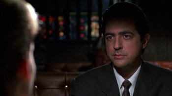 Movie still from “House of Games” (1987), directed by David Mamet – A person wearing a suit and tie; Close Up shot, Over the shoulder angle