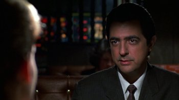 Movie still from “House of Games” (1987), directed by David Mamet – A person wearing a suit and tie; Close Up shot, Over the shoulder angle