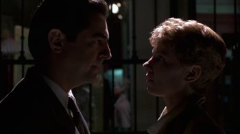 Movie still from “House of Games” (1987), directed by David Mamet – A man and a woman face to face in a dimly - lit room; Close Up shot, Low angle