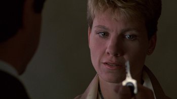 Movie still from “House of Games” (1987), directed by David Mamet – A woman is looking at her reflection in a mirror; Close Up shot, Over the shoulder angle
