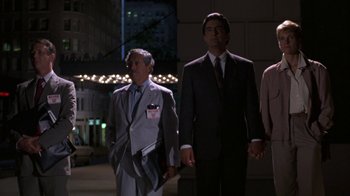 Movie still from “House of Games” (1987), directed by David Mamet – Two men and a woman standing in the dark; Medium shot, Low angle