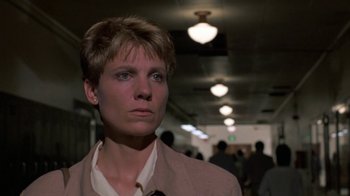 Movie still from “House of Games” (1987), directed by David Mamet – A woman with short blonde hair wearing a suit; Close Up shot, Low angle