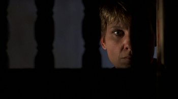 Movie still from “House of Games” (1987), directed by David Mamet – A woman looking through a window at night; Close Up shot, Low angle