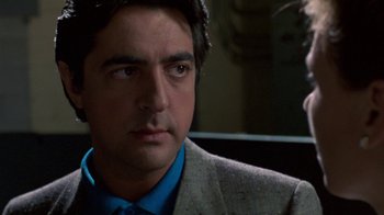 Movie still from “House of Games” (1987), directed by David Mamet – A person wearing a suit and tie; Close Up shot, Over the shoulder angle