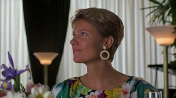Movie still from “House of Games” (1987), directed by David Mamet – A person wearing a dress and earrings; Close Up shot, Low angle