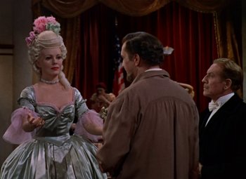 Movie still from “House of Wax” (1953), directed by André De Toth – Two men and a woman dressed up for a party; Medium shot, Over the shoulder angle