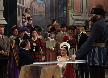 Movie still from “House of Wax” (1953), directed by André De Toth – A group of people standing in front of a painting; Wide shot, Low angle