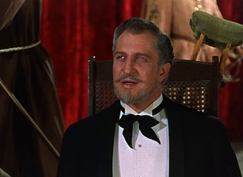 Movie still from “House of Wax” (1953), directed by André De Toth – An older man in a tuxedo sitting in a chair; Close Up shot, Low angle