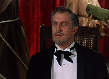 Movie still from “House of Wax” (1953), directed by André De Toth – A man in a tuxedo sitting in a chair; Close Up shot, Low angle