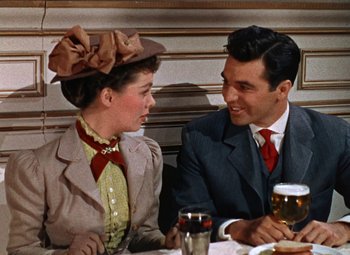 Movie still from “House of Wax” (1953), directed by André De Toth – A man and a woman sitting at a dinner table; Medium shot, Over the shoulder angle