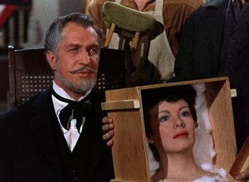 Movie still from “House of Wax” (1953), directed by André De Toth – An older man holding a wooden box in front of an older woman; Close Up shot, High angle