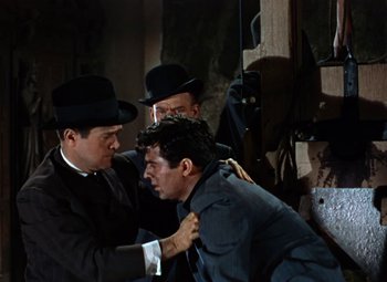 Movie still from “House of Wax” (1953), directed by André De Toth – A group of men standing next to each other in a room; Medium shot, Low angle