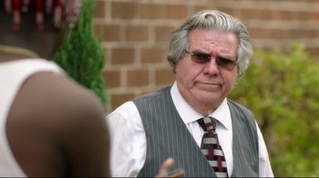 Movie still from “How High 2” (2019), directed by Bruce Leddy – An older man wearing a vest and tie; Close Up shot, Over the shoulder angle