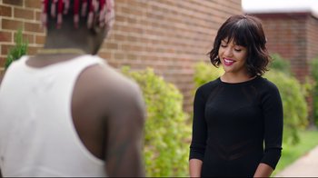 Movie still from “How High 2” (2019), directed by Bruce Leddy – A woman standing next to a brick wall; Medium shot, Over the shoulder angle