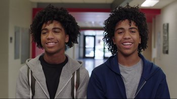 Movie still from “How High 2” (2019), directed by Bruce Leddy – Two young men standing next to each other in front of a building; Close Up shot, Overhead angle