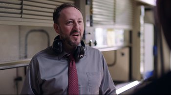 Movie still from “How High 2” (2019), directed by Bruce Leddy – A man wearing headphones and a shirt and tie; Close Up shot, Over the shoulder angle